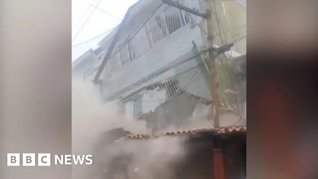 People flee as building collapses on the outskirts of Caracas