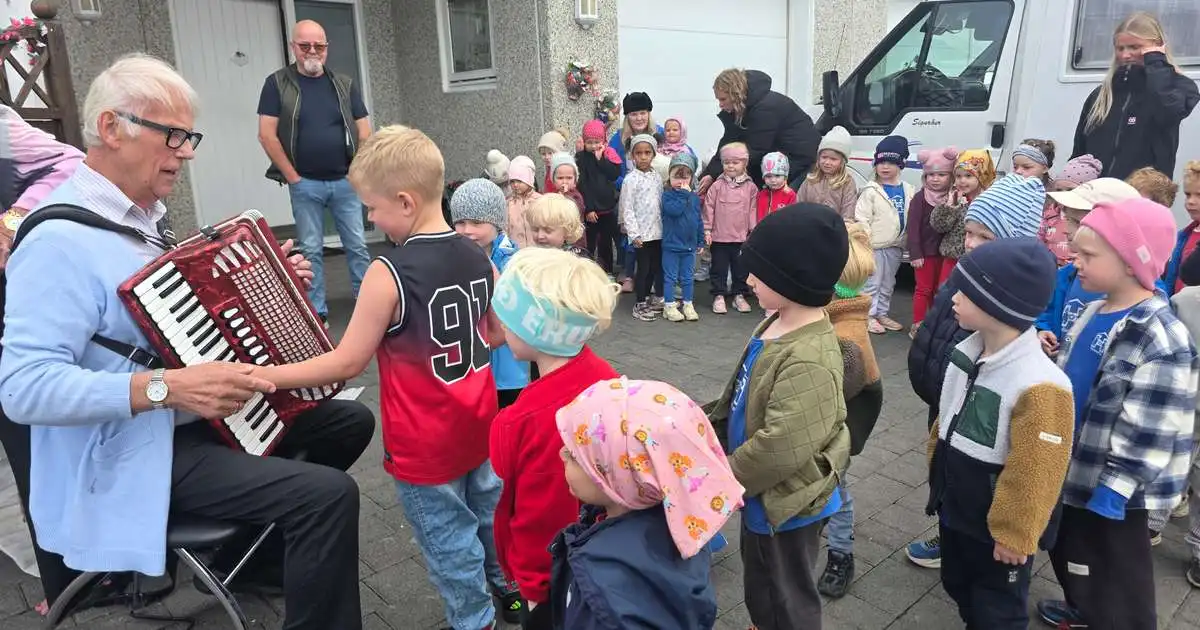 Syngjandi leikskólabörn með 90 ára harmonikkuleikara